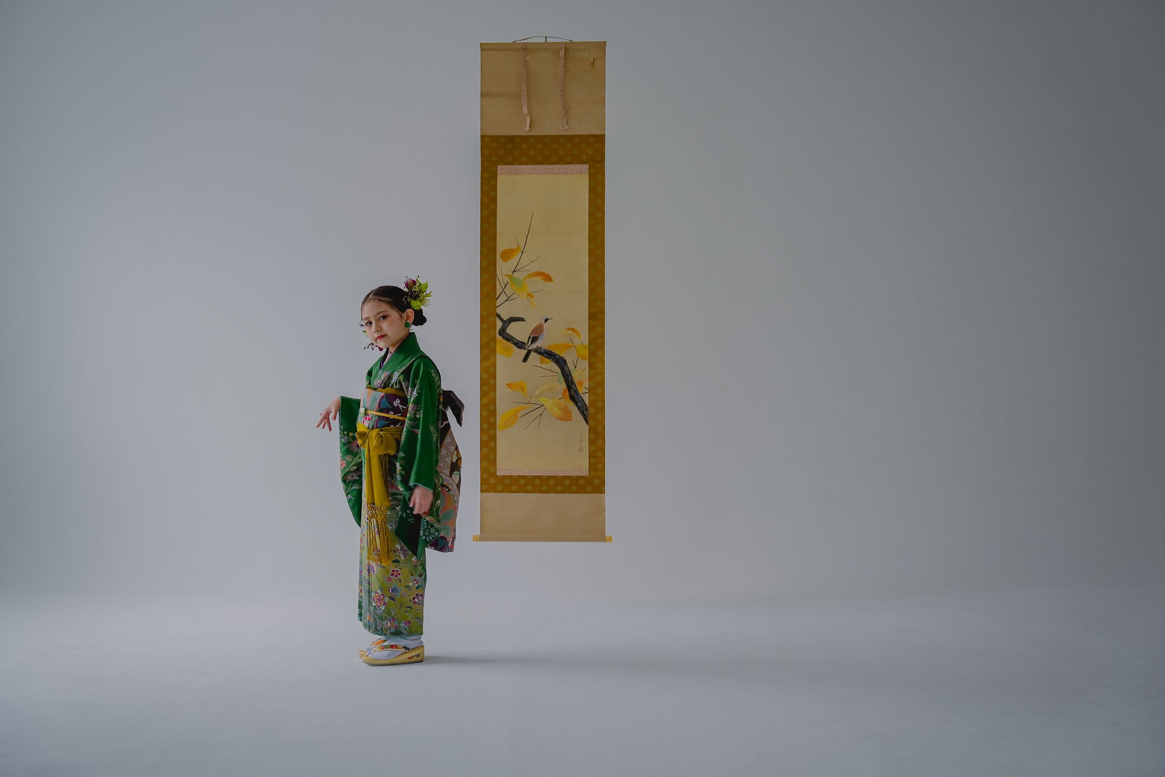 Maison nr. 掛け軸の前で緑の着物を着た七五三の撮影